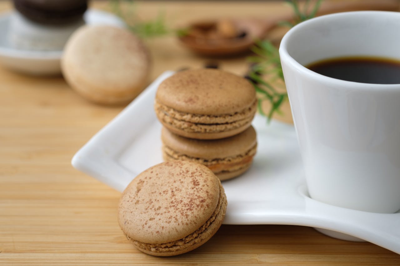 A close-up of French macarons served with a cup of coffee, perfect for a gourmet dessert setting.